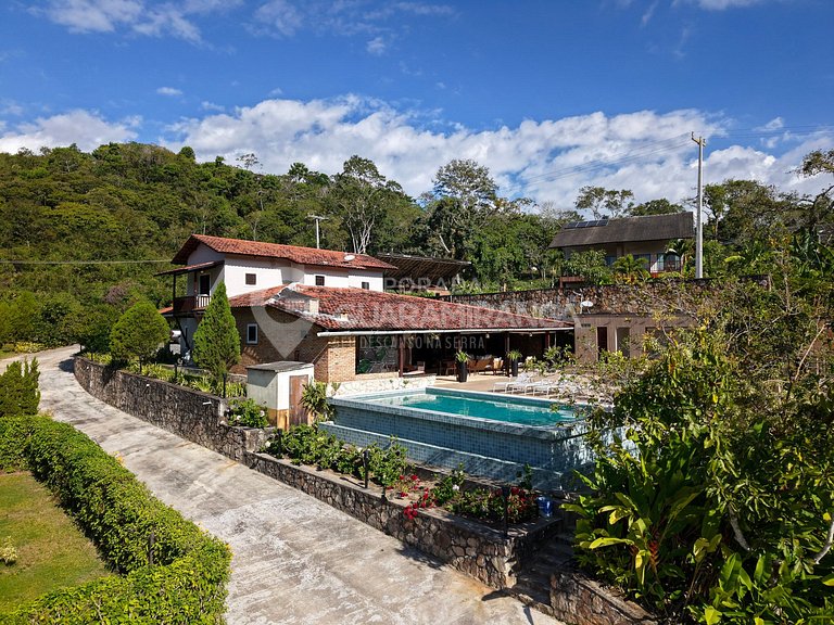 Piscina de borda infinita e vista da serra